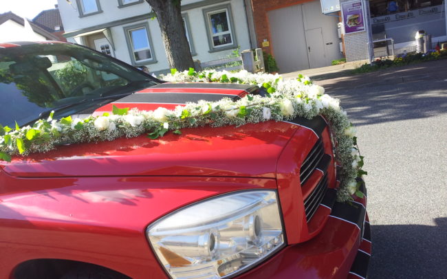 Hochzeit Blumendeko auf einer Motorhaube von einem Auto